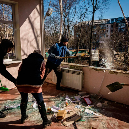Freiwillige helfen bei der Säuberung einer Kinderschule, die dem angegriffenen Wohngebiet in Kiew, Ukraine, gegenüberstand