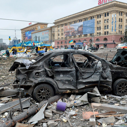 Trümmer und die ausgebrannte Hülle eines Automülls Platz der Freiheit vor dem Rathaus in Charkiw, Ukraine