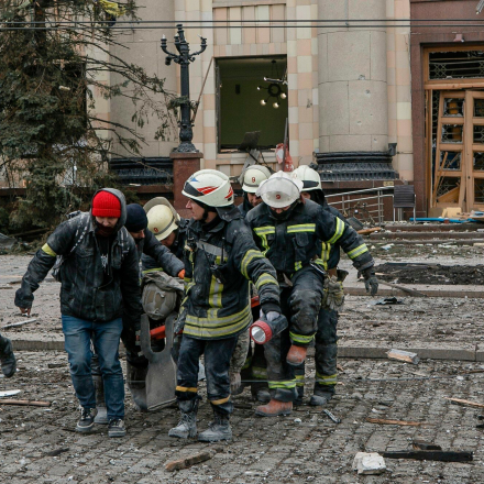 Ukrainische Rettungskräfte tragen die Leiche eines Opfers aus dem beschädigten Rathausgebäude nach Beschuss in Charkiw, Ukraine