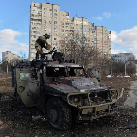 Ein Kämpfer der ukrainischen Territorialverteidigung untersucht nach dem Angriff auf Charkiw ein zerstörtes russisches Infanterie-Mobilitätsfahrzeug GAZ Tigr