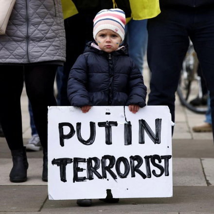 A very young protester holds a placard up during a protest in Trafalgar Square in London, UK