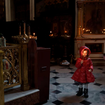 A girl with a candle walks in St. Volodymyrs Cathedral in Kyiv, Ukraine
