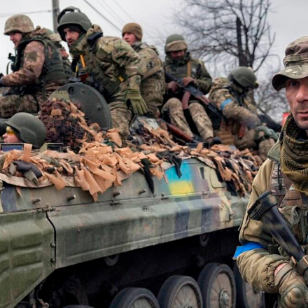 Ein ukrainischer Soldat geht neben einem Kampffahrzeug außerhalb von Kiew, Ukraine