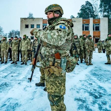 Ein Militärtrainer der 112. Territorialen Verteidigungsbrigade der Ukraine arbeitet während einer Militärübung mit Zivilisten zusammen