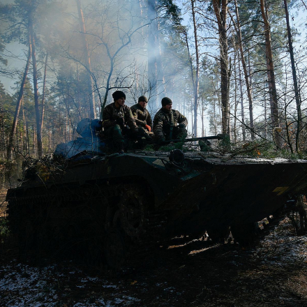 Members of the Ukrainian Armed Forces sit on a military vehicle near Demydiv during the Russian invasion of Ukraine