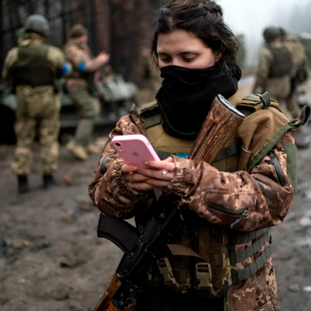 Ukrainian army soldier Dasha, 22, checks her phone after a military sweep on the outskirts of Kyiv