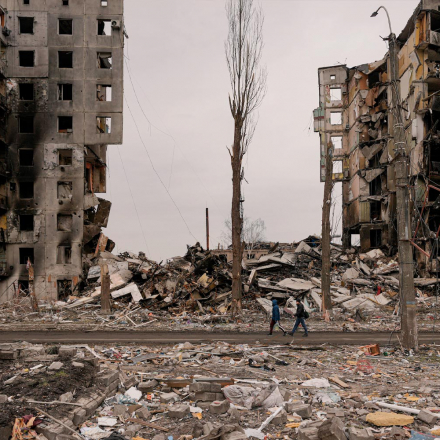 People walk by an apartment building destroyed during fighting between Ukrainian and Russian forces in Borodyanka, Ukraine