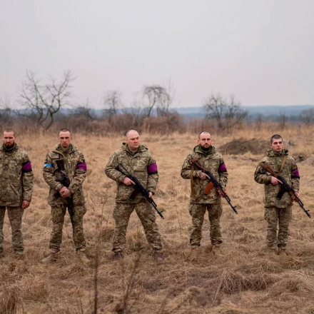 Ukrainian servicemen prepare to fire salutes during the funeral of their comrades